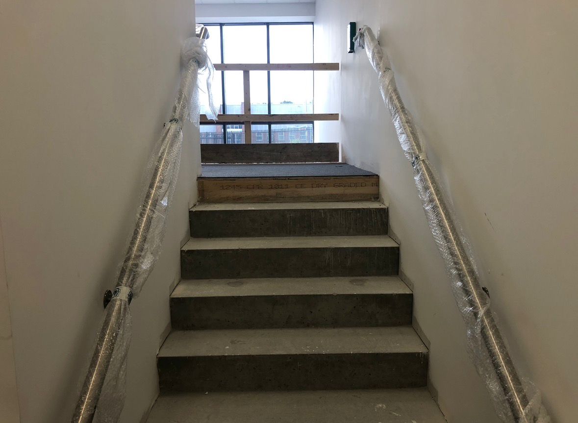 Stainless steel handrails on commercial concrete staircase