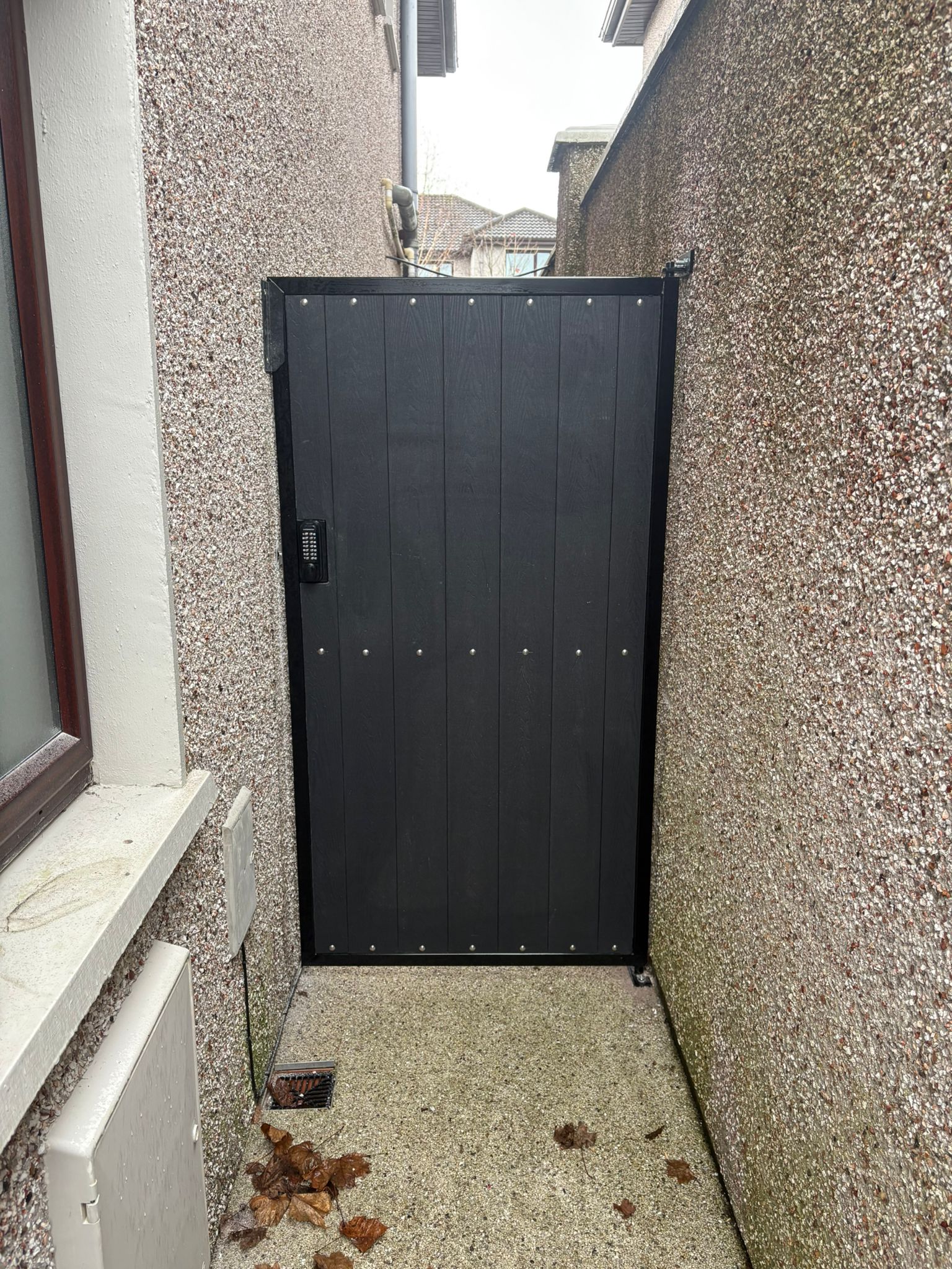 Black powder-coated steel side access gate with keypad